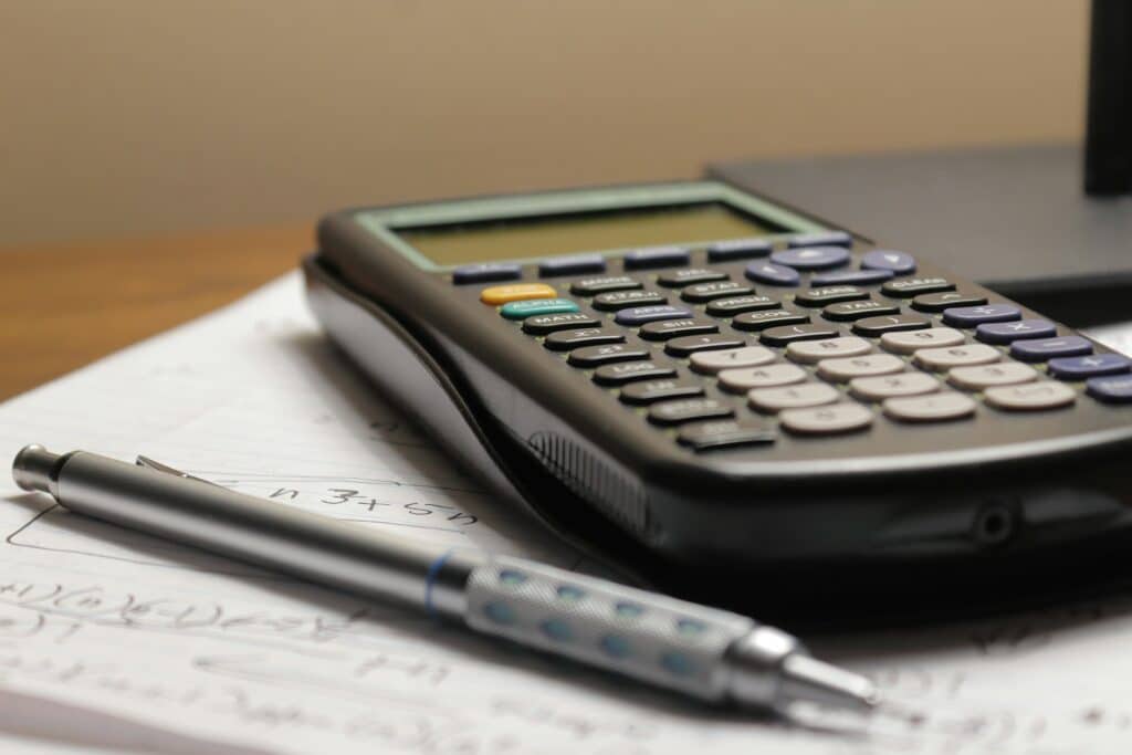 a calculator and a pen of a person in need of payroll services