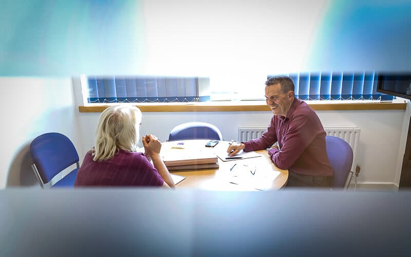 a sole trader sitting down with an accountant for sole traders in an office